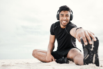 Beach, headphones or portrait of happy man stretching legs with fitness for body flexibility, music or podcast. Sand, smile or sports athlete in workout, mobility training or exercise warm up at sea