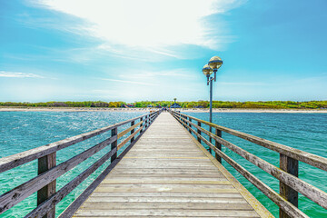 Obraz premium walkway to the sea. wooden passage, bridge over the ocean. Seebrücke Graal Müritz, Ostsee, Baltic Sea, Deutschland. view from the bridge to land 