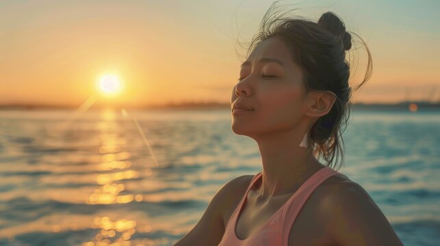 An Asian young woman gracefully performs the Gomukhasana pose by the sea engaging in advanced yoga for stretching strengthening and relaxation embodying the essence of holistic health care