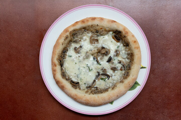 Above view of Pizza topped with truffle mushrooms and dense cheese. Arrange on a round plate. and...