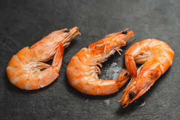 Shrimp on a black mica board Three royal red prawns on a board are ready to serve. Selected focus