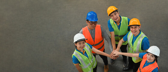 Group of industrial warehouse Asian workers stacking hands together, successful or deal commitment, Logistics and warehouse business and celebrating Labor Day, Top view and banner cover concept