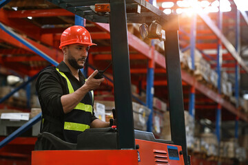 Caucasian Foreman stays on lifting forklift container cargo forklift using walkie talkie for...