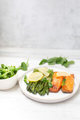 Baked salmon and asparagus with salad and lemon. Top view.  