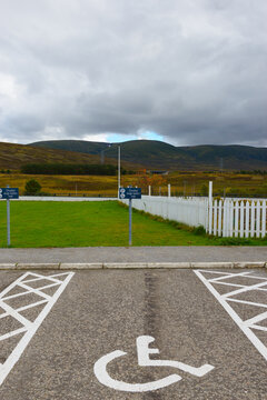 A disabled parking space with symbol and sign in a car park, vertical portrait format