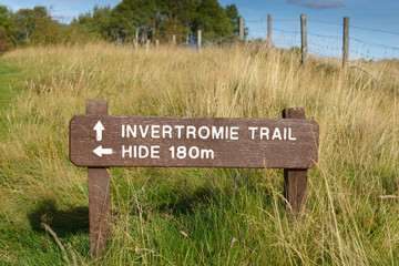 A wooden sign for the Invertromie Trail at Insh Marshes, Badenoch and Strathspey, Highland,...