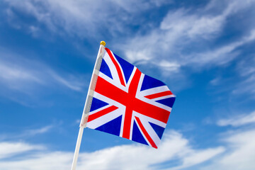 Union Jack in front of blue sky and white clouds