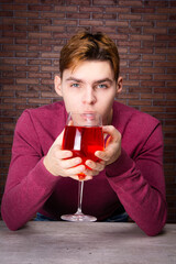 Happy holidays. A man drinks a red alcoholic drink on New Year's Eve.