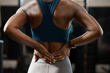 Plakat Back pain, training and person hands for exercise injury, risk or muscle health in gym with tension. Medical, spine and athlete with massage for body strain in fitness, sports or workout and support