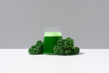 Batido de desintoxicación de jugo de col rizada verde y hojas frescas de col rizada sobre fondo...