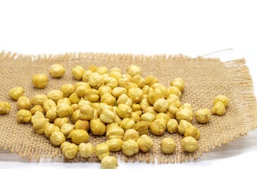 Roasted Chickpea or Garbanzo Bean Isolated on Burlap Fabric Background in Horizontal Orientation, Also Known as Bengal Gram or Egyptian Pea