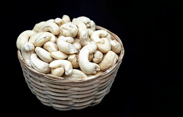 Cashew Nut in a Bamboo Basket Isolate on Black Background with Copy Space