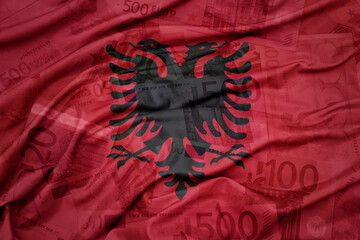 waving colorful national flag of albania on a euro money banknotes background. finance concept. .