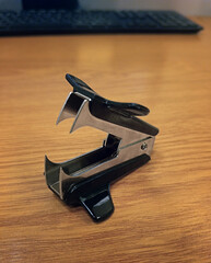 One black staple remover isolated on white, top view