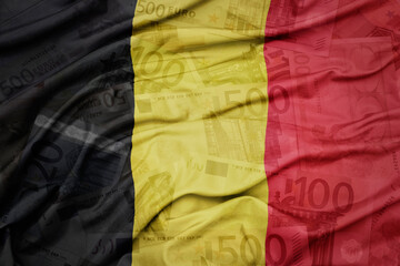 waving colorful national flag of belgium on a euro money banknotes background. finance concept.
