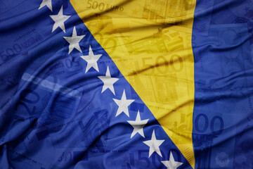 waving colorful national flag of bosnia and herzegovina on a euro money banknotes background. finance concept.