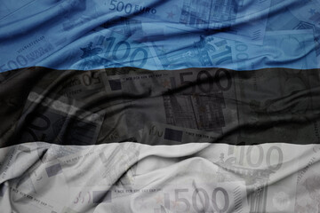 waving colorful national flag of estonia on a euro money banknotes background. finance concept.