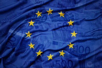 waving colorful national flag of european union on a euro money banknotes background. finance concept.
