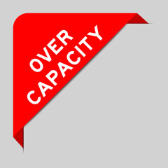 Red color of corner label banner with word over capacity on gray background