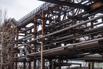 Abandoned industrial equipment. Steel pipelines, cables and piping.