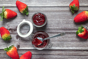 Tasty and healthy homemade strawberry jam. Top view of a table with a jar of homemade strawberry jam