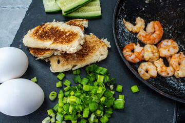Fried shrimp on the table with warmed bread toast, green onions and eggs. Delicious and healthy food. Selected Focus