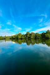 Lake Wohrder, a beach view of the lake from the shore in Nuremberg. Fantastic view of the reflection of trees and blue sky in the water