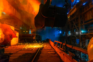 Industrial workers working in a metallurgical plant at night.