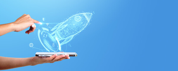 A hand appears to swipe a holographic image of a rocket from a smartphone, symbolizing a startup...