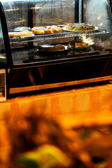 A photo of cheese cakes or desserts show in a coffee shop counter bar or restaurant refrigerator or fridge shelf. Sweets bakery store, modern bistro small or start up business SME. Preparing cake.