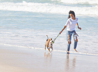 Beach, woman and dog with running with toys for fun, exercise and healthy energy for happy animal in nature. Ocean, girl and playful pitbull with outdoor training, pet fitness and wellness in morning