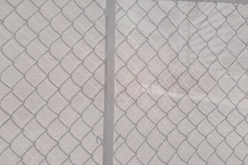 fabric background featuring shadow pattern of a chainlink fence