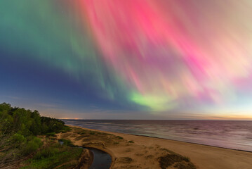 Aurora Borealis northen lights on the Baltic Sea beach in Latvia at May.