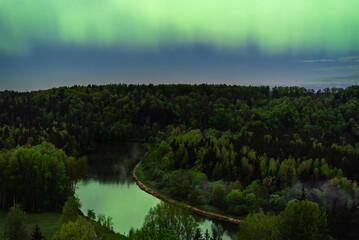 Aurora Borealis northen lights above Gauja river in Sigulda, Latvia  at May.