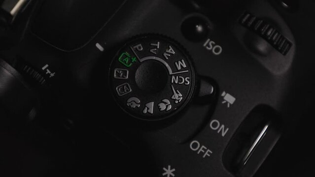 Photography shooting modes digital SLR camera with different buttons and roulettes nearby