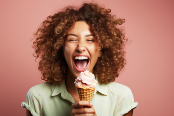 A woman with curly hair holds a pink ice cream cone and smiles against a salmon-colored background....