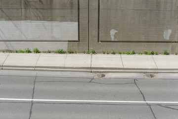 asphalt roadway, sidewalk, and concrete barrier wall