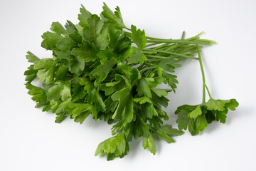 Neatly arranged vibrant green parsley leaves on a clean white surface