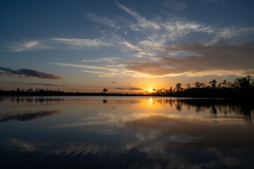 Colorful sunset cloudscape reflected in Pine Glades Lake in Everglades National Park, Florida..