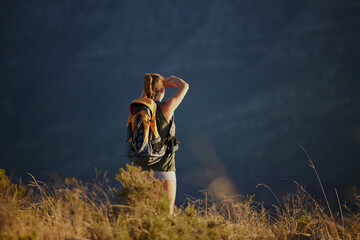 Hiker, mountain and sky in environment for landscape, nature or adventure for extreme sport, travel and explore. Woman, trekking and cliff for view, hiking and journey with backpack in training