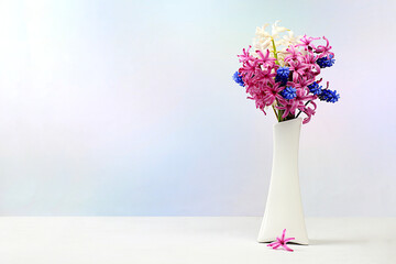 Beautiful spring flowers hyacinths and muscari in a vase on a light background, flyer.Abstract...