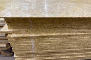 Construction materials store. A stack of OSB boards close-up. Sale of materials for construction and packaging of goods.