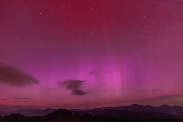 Beautiful violet pink red aurora borealis the northern lights over the horizon in Slovenia.