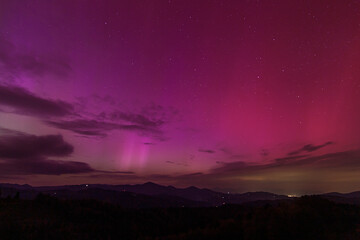 Beautiful violet pink red aurora borealis the northern lights over the horizon in Slovenia.