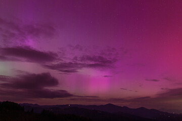 Beautiful violet pink red aurora borealis the northern lights over the horizon in Slovenia.