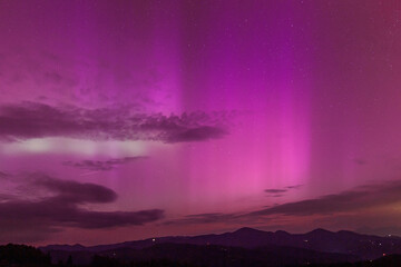 Beautiful violet pink red aurora borealis the northern lights over the horizon in Slovenia.