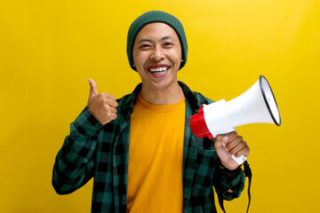 Asian man holds a megaphone with a happy face, smiles at the camera, and shows satisfaction with a...