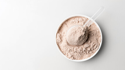 Whey protein powder in measuring scoop, top view