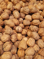 Natural nuts in shell background. Bulk dried fruits. Whole unpeeled walnuts. many nuts in the market. Healthy and organic food. Natural fresh walnut full frame.