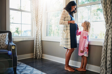 Pregnant, woman and daughter or bonding with stomach for connection, curious and caring for baby in living room. Mother, maternity and touching of tummy for pregnancy growth and development in home